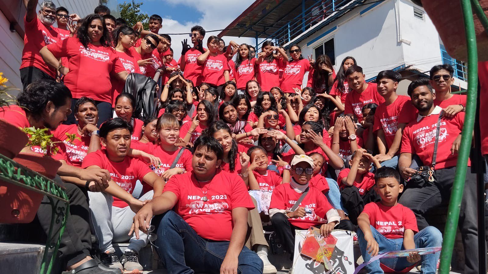 A whole camp in red shirts cheering together
